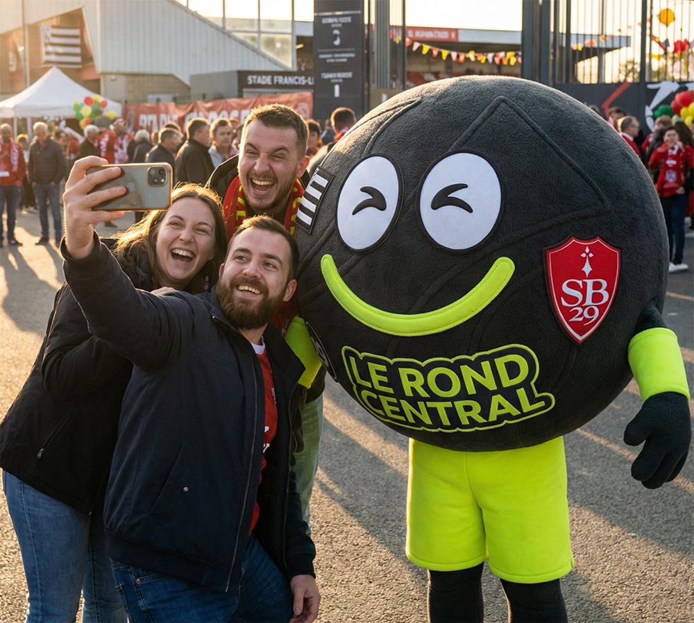 Mascotte Le Rond Central en selfie avec des supporters au stade
